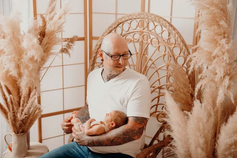 Vater mit Baby im Korbstuhl
