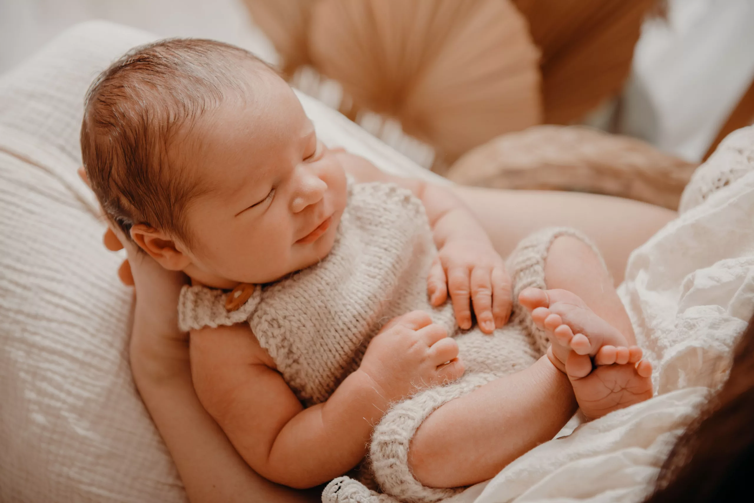 Baby liegt geborgen auf Mamas Schoß