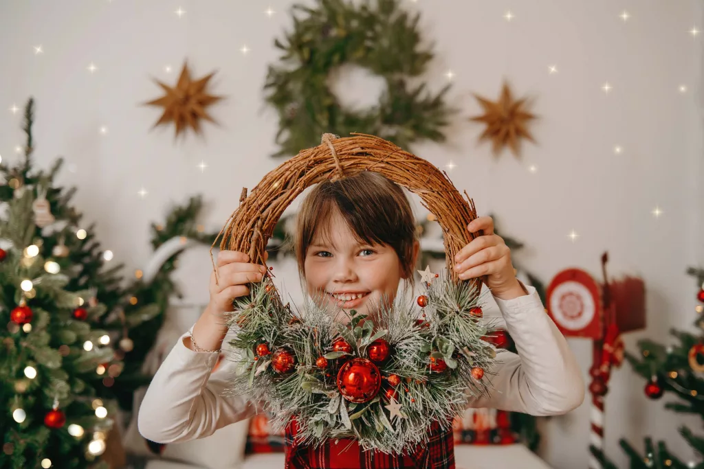 Mädchen hält Weihnachtskranz
