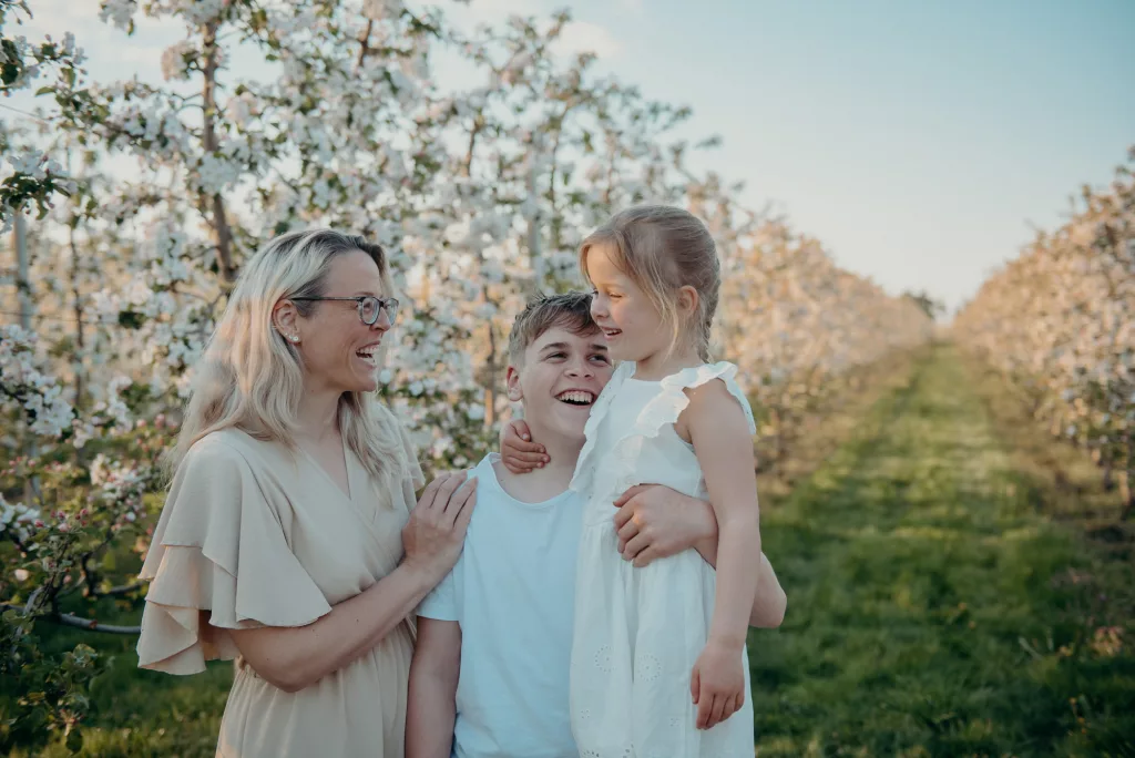 Familie beim Frühlingsshooting auf einer Apfelbaumwiese