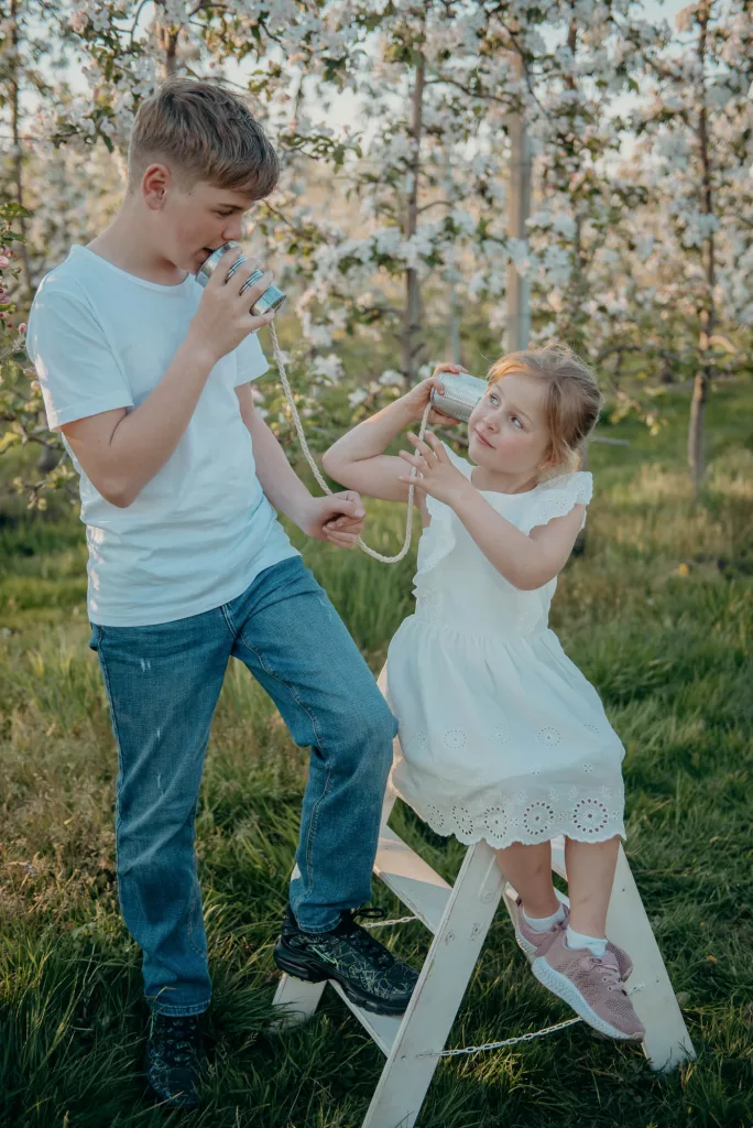 Bruder und Schwester beim Familienshooting auf einer Apfelbaumwiese